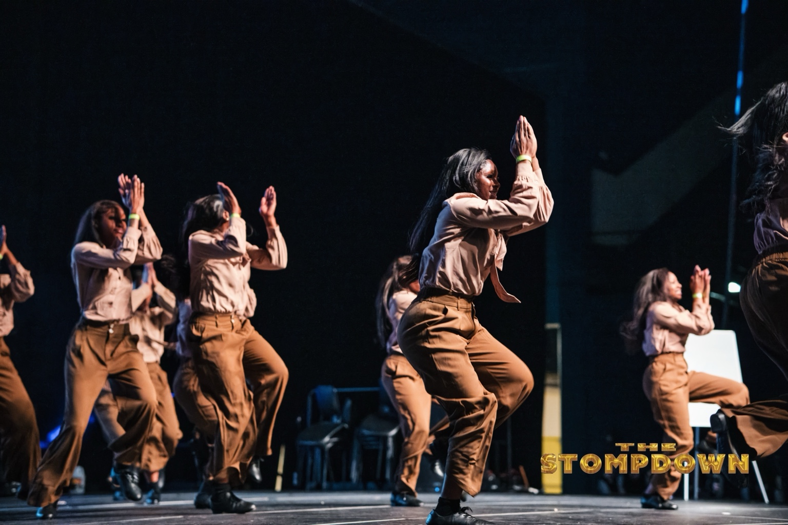 Step team performing in brown costumes on The Stompdown stage