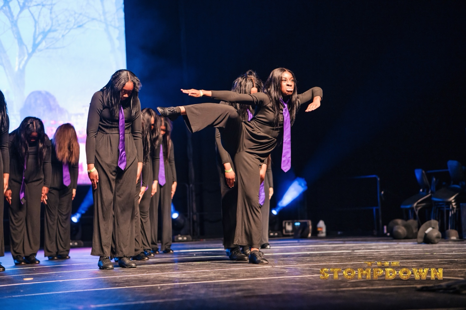 Performers extending their arms during a synchronized step routine