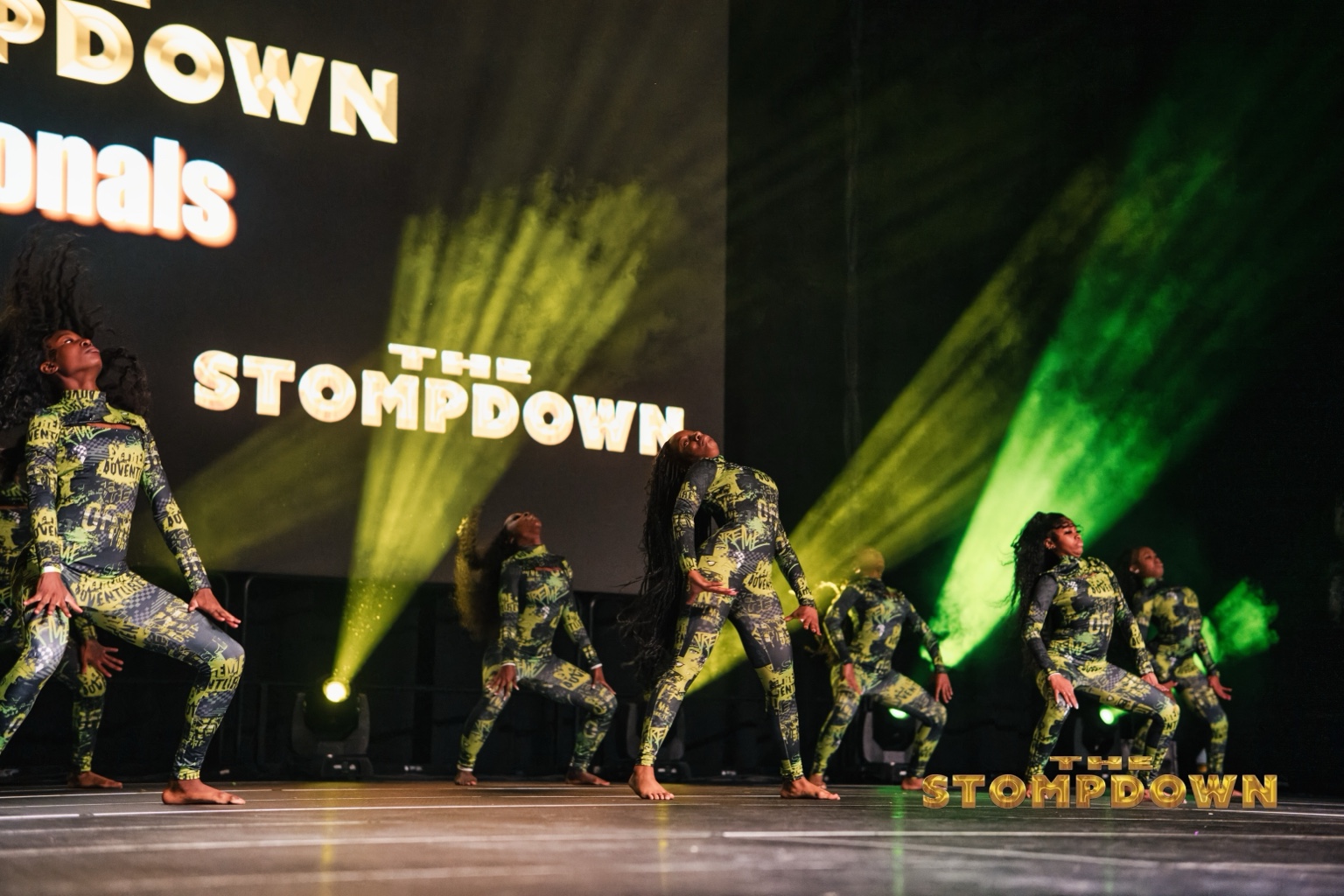 Step team performing under green stage lights