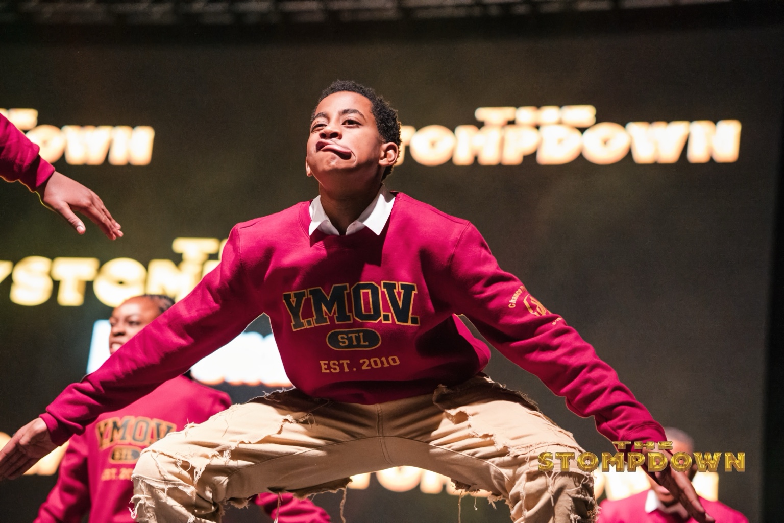 Performer in a red sweatshirt stepping on stage