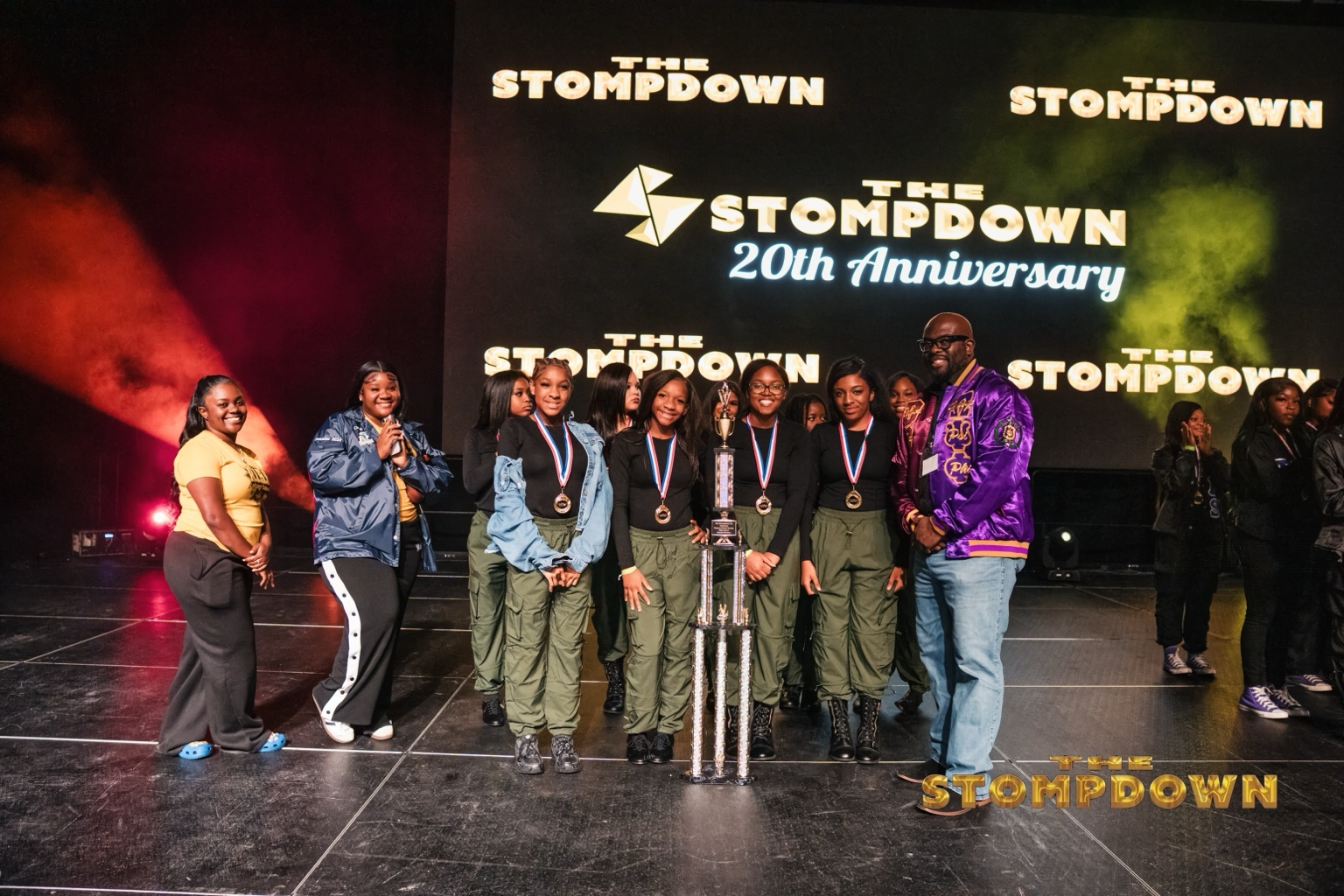 Team posing on stage with The Stompdown championship trophy